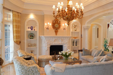 Aménagement d'un grand salon méditerranéen avec un mur beige, un sol en marbre, une cheminée double-face et un manteau de cheminée en pierre.