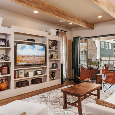 Large mountain style open concept medium tone wood floor and brown floor living room photo in Houston with no fireplace, a media wall and beige walls
