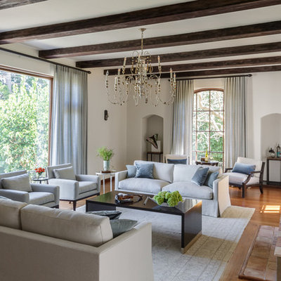 Inspiration for a large transitional open concept medium tone wood floor and brown floor living room remodel in San Francisco with white walls, a standard fireplace, a wood fireplace surround and no tv