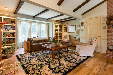 Photo of a medium sized traditional open plan living room in Philadelphia with white walls, light hardwood flooring, a standard fireplace, a brick fireplace surround and brown floors.