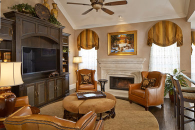 ダラスにある高級な広いトラディショナルスタイルのおしゃれなリビング (濃色無垢フローリング、石材の暖炉まわり、ベージュの壁、標準型暖炉、埋込式メディアウォール、茶色い床) の写真