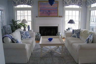 Mid-sized trendy formal and enclosed light wood floor living room photo in Boston with blue walls, a standard fireplace, a wood fireplace surround and no tv