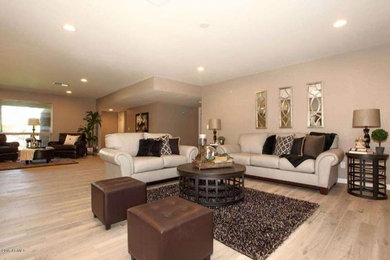 Example of a large transitional open concept light wood floor and beige floor living room design in Phoenix with beige walls, no fireplace and a tv stand