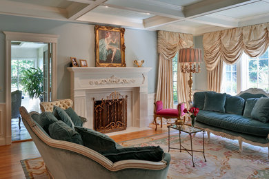 Example of a large classic formal and enclosed medium tone wood floor living room design in Boston with blue walls, a standard fireplace, no tv and a plaster fireplace
