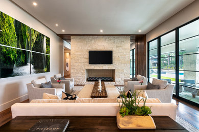 Inspiration for a mid-sized modern formal and open concept dark wood floor and brown floor living room remodel with white walls, a standard fireplace, a stone fireplace and a wall-mounted tv