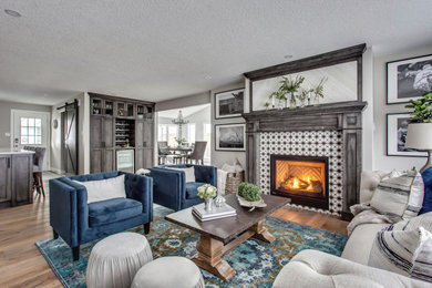 Example of a mid-sized trendy formal and open concept light wood floor and gray floor living room design in Calgary with gray walls, a standard fireplace, a tile fireplace and no tv