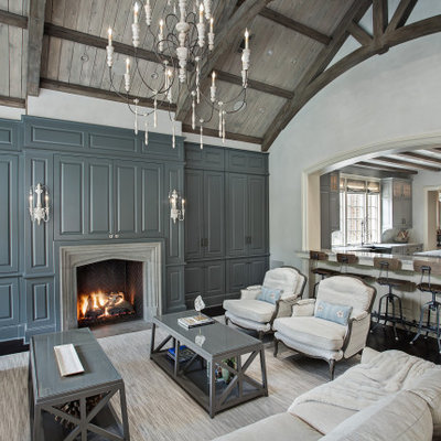 Living room - mid-sized traditional open concept dark wood floor and black floor living room idea in Houston with gray walls, a standard fireplace, a stone fireplace and a concealed tv