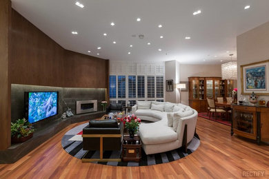 Example of a large trendy open concept medium tone wood floor and brown floor living room design in Los Angeles with a music area, beige walls, a standard fireplace, a metal fireplace and a wall-mounted tv
