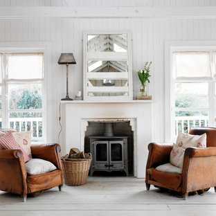 Idee per un soggiorno stile shabby con pareti bianche, parquet chiaro e stufa a legna