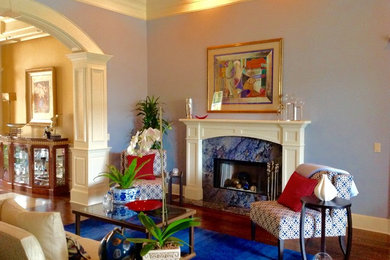 This is an example of a medium sized classic formal enclosed living room in Orange County with blue walls, medium hardwood flooring, a standard fireplace, a stone fireplace surround, no tv and brown floors.