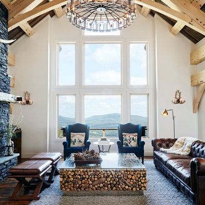 Living room - rustic formal dark wood floor living room idea in New York with white walls and a stone fireplace