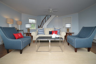 Cette image montre un salon marin de taille moyenne et fermé avec une salle de réception, un mur bleu, un sol en bois brun, aucune cheminée et un sol marron.