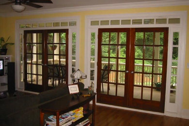 Ejemplo de salón abierto tradicional de tamaño medio con paredes amarillas, suelo de madera oscura y suelo marrón