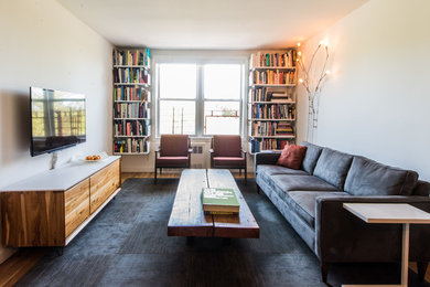 Imagen de biblioteca en casa cerrada contemporánea de tamaño medio sin chimenea con paredes blancas, suelo de madera en tonos medios y televisor colgado en la pared