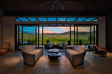 This is an example of a large contemporary open plan living room in Denver with grey walls, concrete flooring, a ribbon fireplace, a concrete fireplace surround, no tv and grey floors.