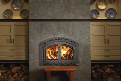 Example of a mid-sized mountain style enclosed ceramic tile and brown floor living room design in Other with beige walls, a standard fireplace and a metal fireplace