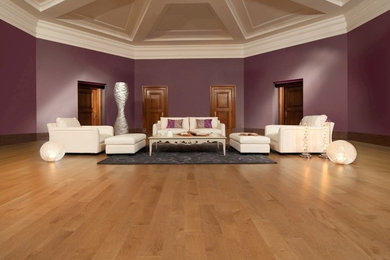Modelo de salón para visitas cerrado actual grande sin chimenea y televisor con paredes púrpuras, suelo de madera clara y suelo beige