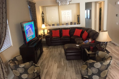 Example of a mid-sized classic brown floor and ceramic tile living room design in Las Vegas with beige walls, no fireplace and a tv stand