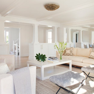 Cette photo montre un salon chic ouvert avec une salle de réception, un mur blanc, un sol en bois clair, une cheminée standard, un manteau de cheminée en bois et aucun téléviseur.