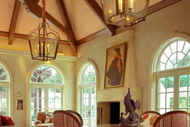 Imagen de salón abierto tradicional con paredes beige, suelo de madera en tonos medios, todas las chimeneas y marco de chimenea de piedra