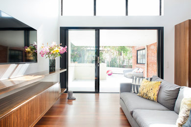 This is an example of a contemporary open plan living room in Brisbane with a wall mounted tv.