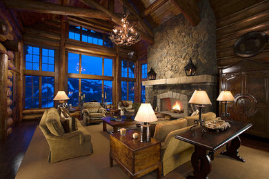 Inspiration for a large rustic open concept dark wood floor living room remodel in Denver with brown walls, a standard fireplace, a stone fireplace and a concealed tv