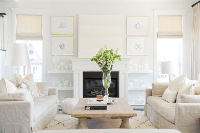 バンクーバーにあるお手頃価格のトランジショナルスタイルのおしゃれなLDK (白い壁、標準型暖炉、木材の暖炉まわり) の写真