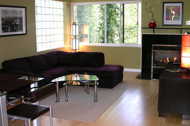 This is an example of a medium sized classic formal enclosed living room in Portland with green walls, light hardwood flooring, a standard fireplace, a metal fireplace surround and no tv.