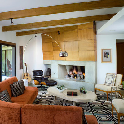 Example of a trendy formal living room design in Los Angeles with white walls, a standard fireplace and a concrete fireplace