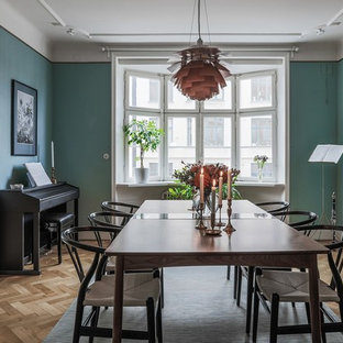 Nordisk inredning av en separat matplats, med gröna väggar, ljust trägolv och beiget golv