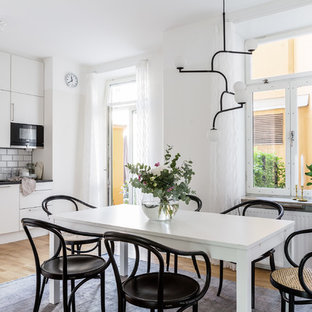 Inredning av ett nordiskt mellanstort kök med matplats, med vita väggar, mellanmörkt trägolv och brunt golv