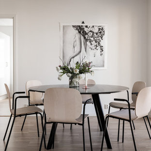 Minimalistisk inredning av en separat matplats, med vita väggar, brunt golv och ljust trägolv