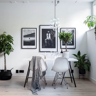 Immagine di una sala da pranzo scandinava chiusa e di medie dimensioni con pareti bianche e parquet chiaro
