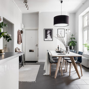 Inredning av ett nordiskt litet kök med matplats, med vita väggar, svart golv och betonggolv