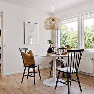 Idéer för en modern matplats, med vita väggar, mellanmörkt trägolv och brunt golv