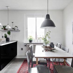 Inredning av ett skandinaviskt kök med matplats, med vita väggar, mörkt trägolv och grått golv