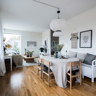 Inspiration för nordiska matplatser med öppen planlösning, med vita väggar, mellanmörkt trägolv och brunt golv
