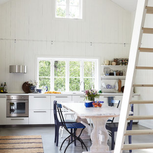 Ispirazione per un'ampia sala da pranzo aperta verso la cucina scandinava con pavimento in cemento e pareti bianche