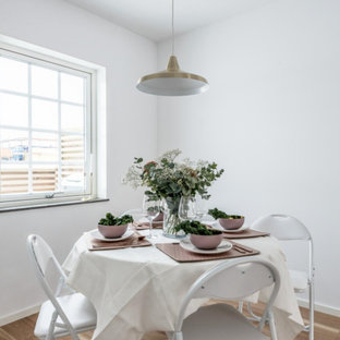 Inspiration för minimalistiska kök med matplatser, med vita väggar, laminatgolv och brunt golv