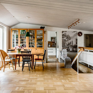 Minimalistisk inredning av en mellanstor matplats, med vita väggar, mellanmörkt trägolv och brunt golv