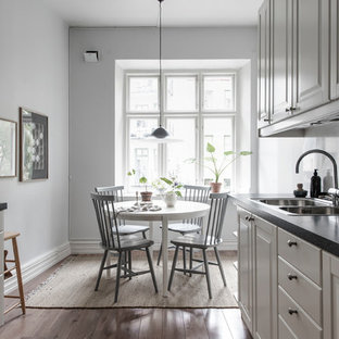 Bild på ett minimalistiskt kök med matplats, med grå väggar, mörkt trägolv och brunt golv
