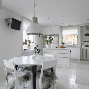 Inredning av ett minimalistiskt mellanstort kök med matplats, med vita väggar och vitt golv