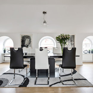 Modern inredning av en stor matplats med öppen planlösning, med vita väggar, ljust trägolv och beiget golv