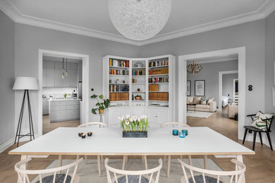 This is an example of a medium sized scandinavian dining room in Stockholm with grey walls, medium hardwood flooring and beige floors.