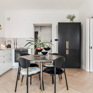 Cette image montre une salle à manger ouverte sur le salon nordique de taille moyenne avec un mur blanc, un sol en bois clair et aucune cheminée.