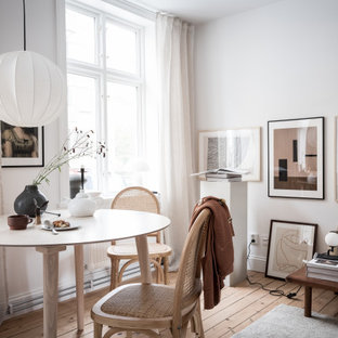 Bild på en minimalistisk matplats med öppen planlösning, med vita väggar, ljust trägolv och beiget golv