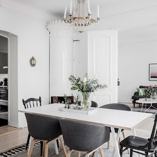 Inredning av en minimalistisk separat matplats, med vita väggar, ljust trägolv, en öppen hörnspis och beiget golv