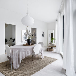 Nordisk inredning av en matplats, med vita väggar, ljust trägolv och grått golv