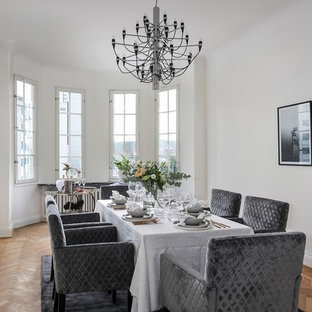 Exempel på en minimalistisk matplats, med vita väggar, mellanmörkt trägolv och beiget golv