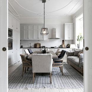 Foto på ett stort minimalistiskt kök med matplats, med vita väggar, ljust trägolv och beiget golv